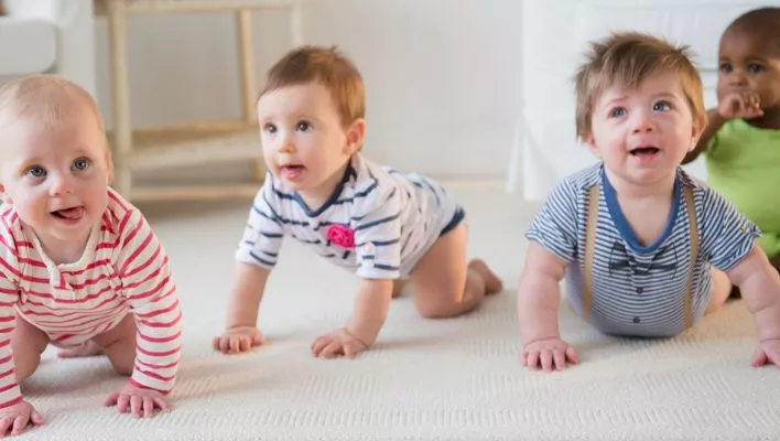 2 babies are crawling while 1 is trying to creep