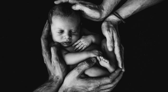 A powerful visual representation unfolds as an adorable baby nestles in the embrace of their loving parents, symbolizing the profound longing and aspiration of dreaming to hold a precious little one in my arms.