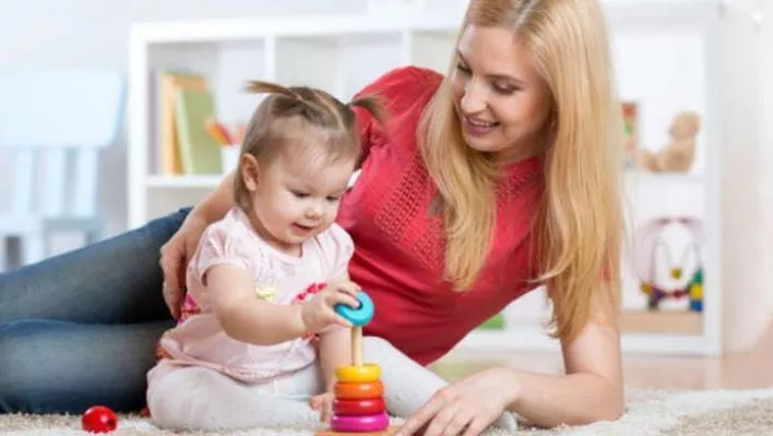 A devoted caregiver engages in joyful play, fostering a special bond with a cherished little one.