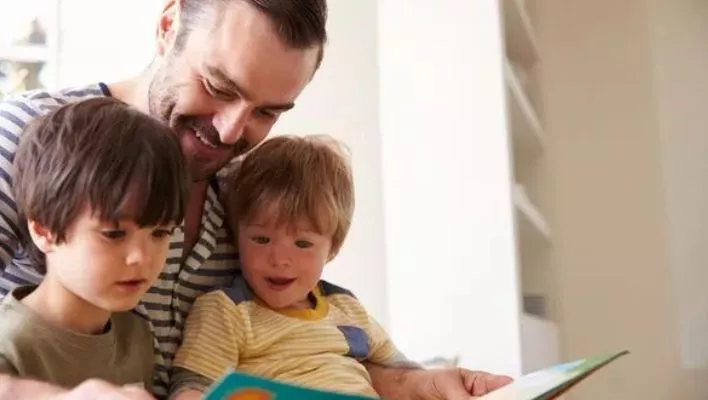 A dedicated dad engages in a teaching moment with his children at home,
