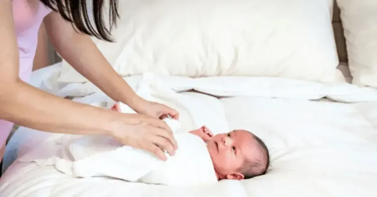 a caring mother expertly swaddling her newborn baby. This explores Swaddles Do I Need?' as it delves into the considerations and essentials for effectively swaddling infants.